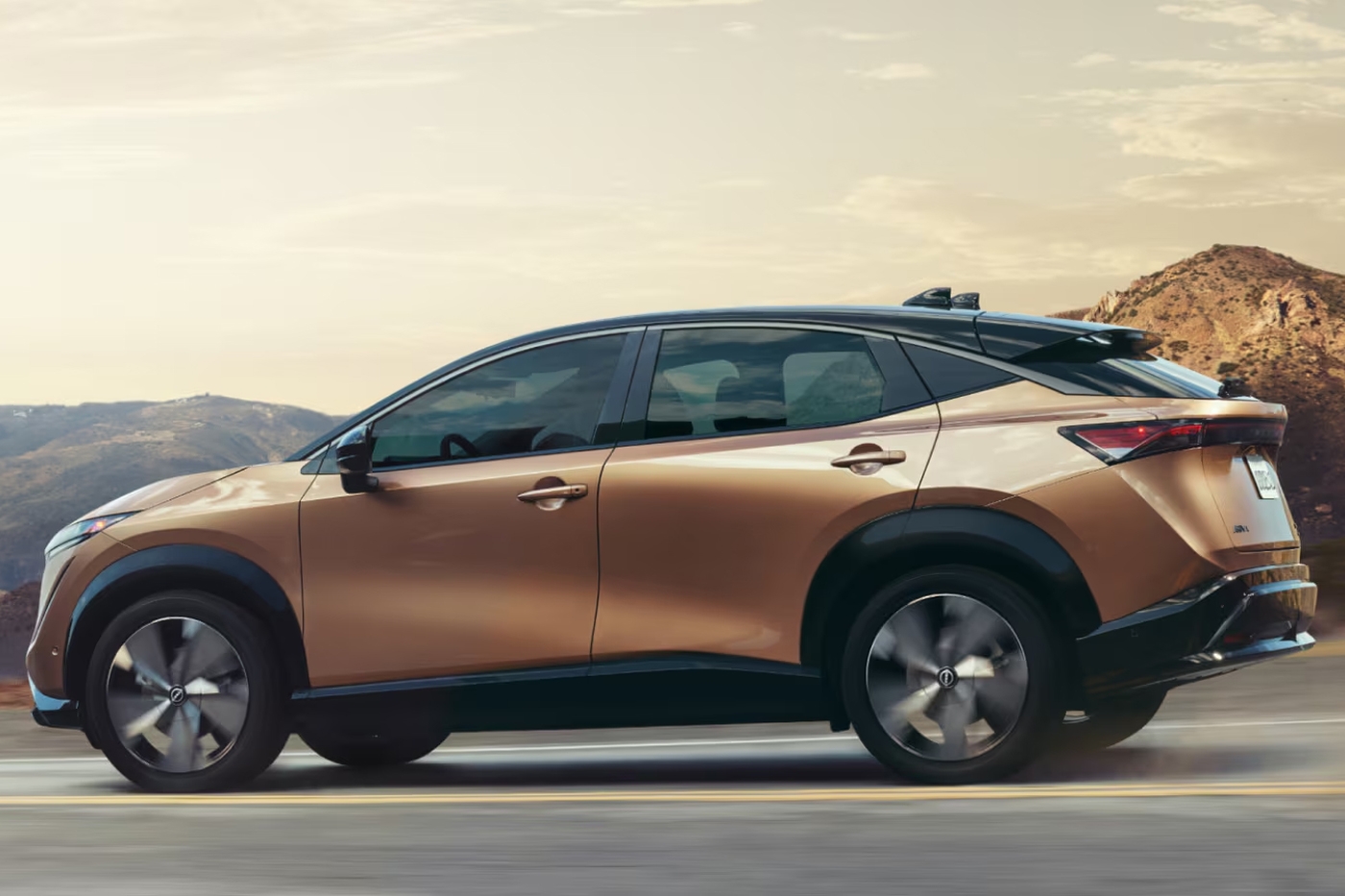 Vue latérale de la Nissan ARIYA 2026 sur route en pleine puissance